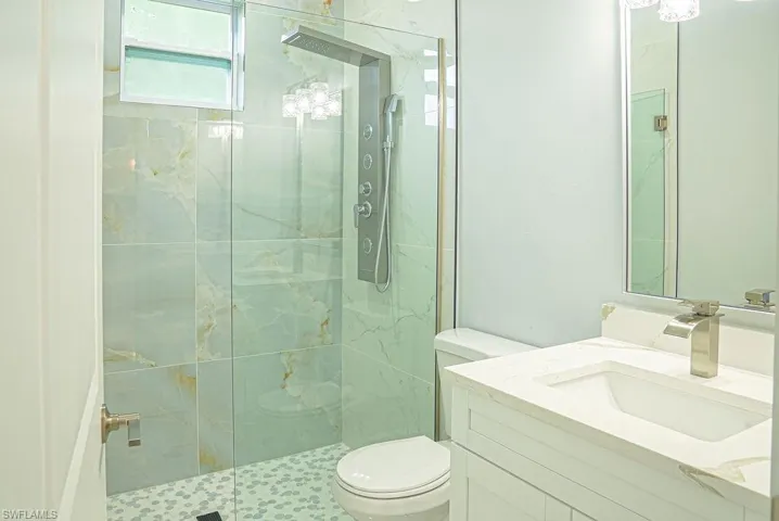 Full bath with a shower stall and vanity