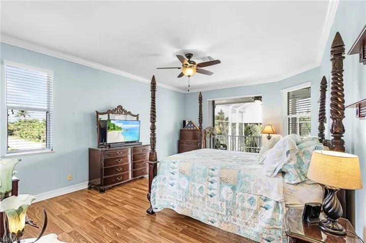 Bedroom featuring ornamental molding, wood finished floors, access to outside, and ceiling fan