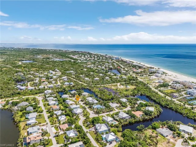 Aerial view of property and surrounding area featuring a nearby body of water and nearby suburban area