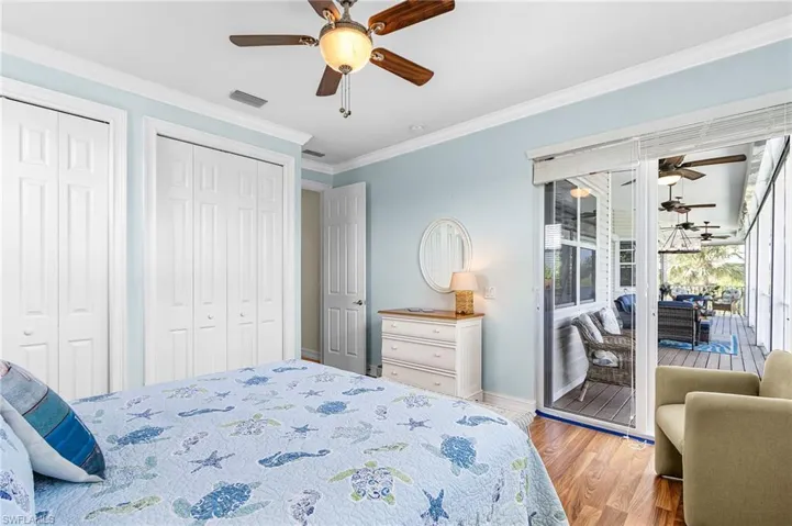 Bedroom with light wood-type flooring, two closets, crown molding, ceiling fan, and access to outside