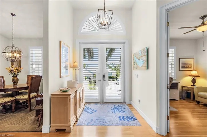 Foyer featuring a chandelier, light wood-style flooring, and a ceiling fan