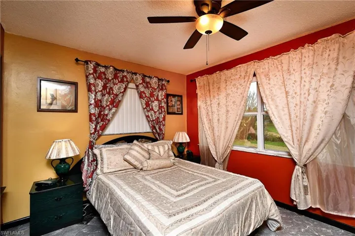 Bedroom with ceiling fan and a textured ceiling