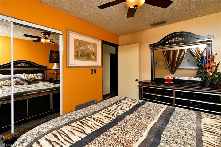 Bedroom with ceiling fan and a textured ceiling
