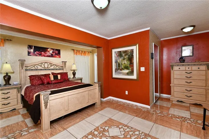 Bedroom featuring ornamental molding and a textured ceiling
