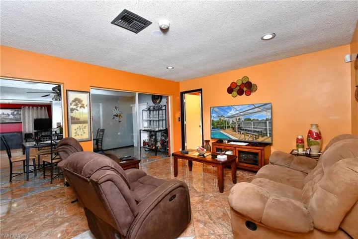 Living room with ceiling fan and a textured ceiling
