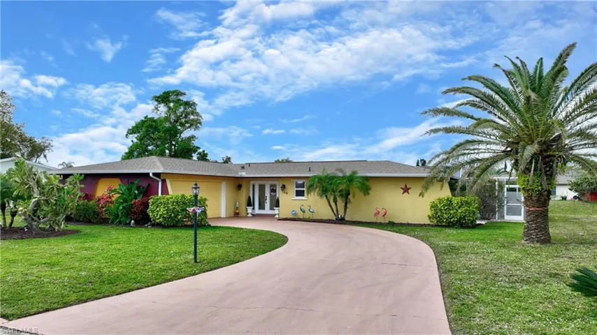Ranch-style home featuring french doors and a front lawn