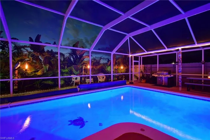 Pool at twilight with a patio and a lanai