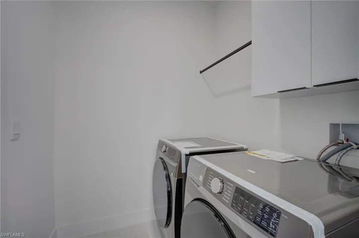 Laundry room featuring separate washer and dryer and cabinet space