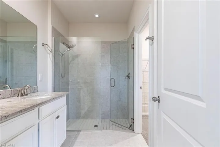 Bathroom with vanity, tile patterned floors, and walk in shower