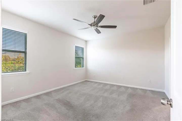 Spare room featuring light colored carpet and ceiling fan