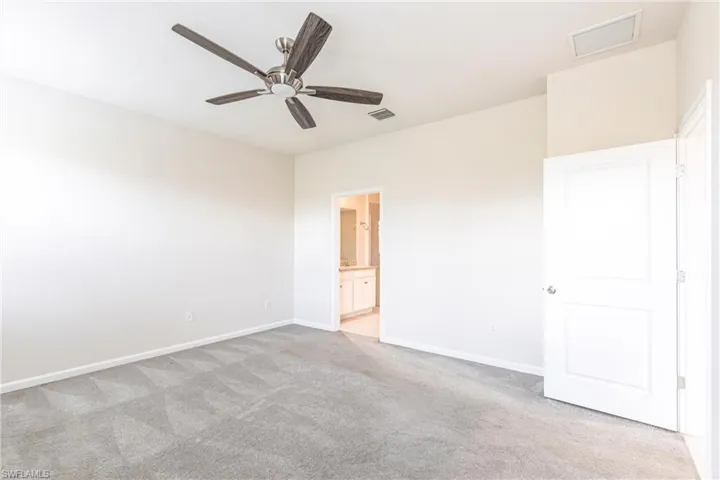Carpeted spare room with ceiling fan