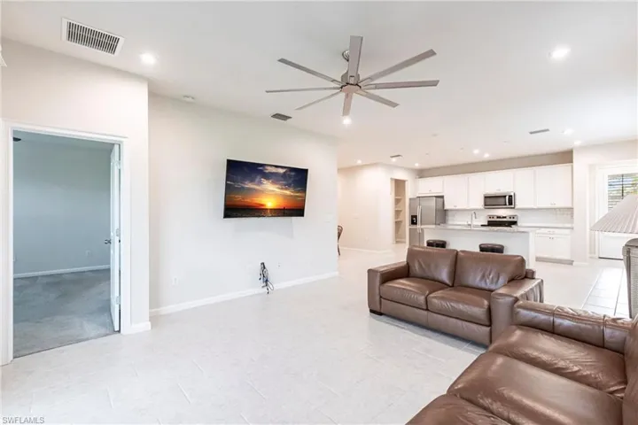 Tiled living room with ceiling fan and sink