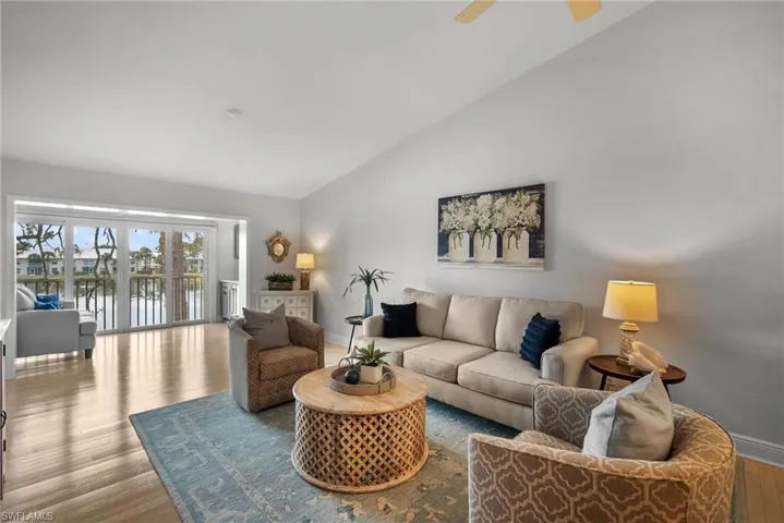 Living room with vaulted ceiling, and water view