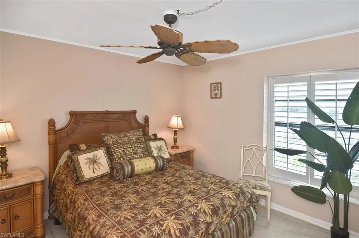 Bedroom with crown molding, ceiling fan, and light wood-type flooring