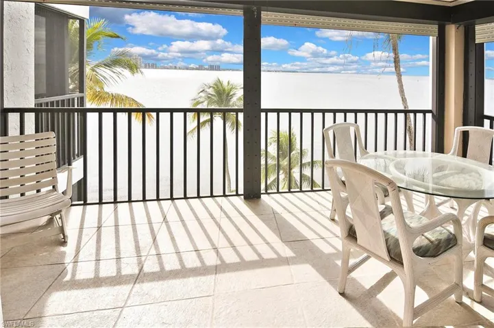 Balcony featuring a water view and outdoor dining space