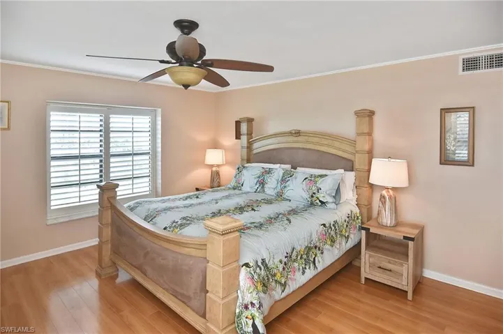 Bedroom with ceiling fan, light wood-style flooring, and crown molding