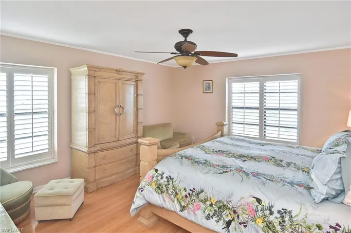 Bedroom with wood finished floors, a ceiling fan, and ornamental molding