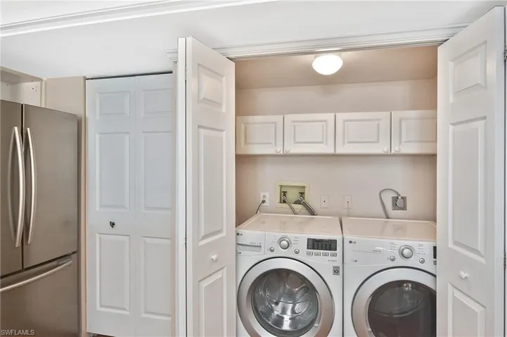 Laundry room featuring washer and clothes dryer and cabinet space