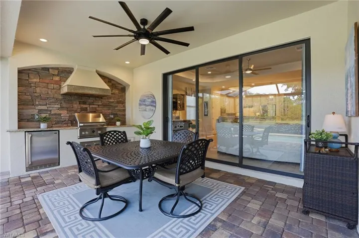 The covered lanai space features a summer kitchen and a space for dining or seating