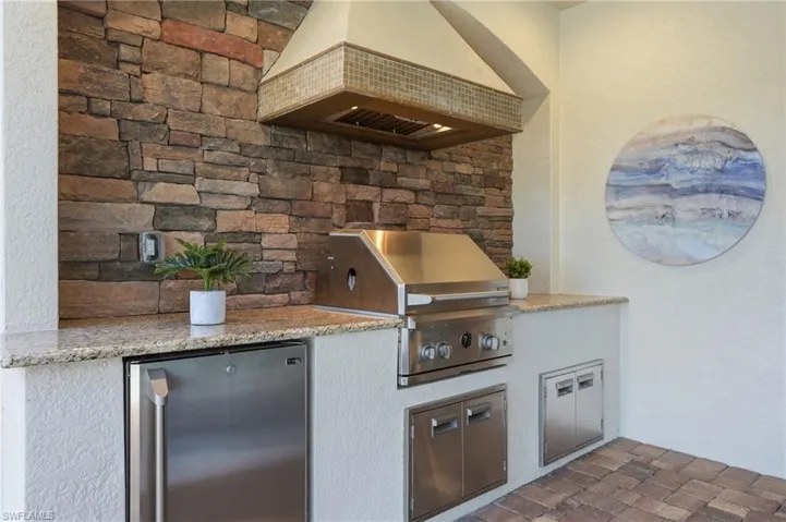 Summer Kitchen featured a fridge, generous counter space, with additional storage plus a custom hood