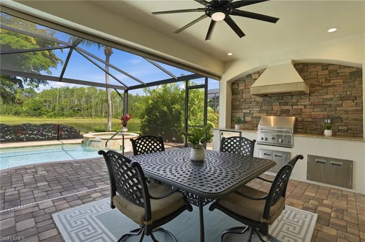 Summer Kitchen and covered lanai space features a close and go electric storm screen for peace of mind when you are out of town