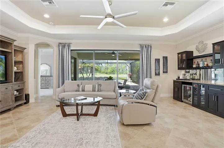 The great room living room area features spectacular views, a built in bar area and beautiful tray ceilings