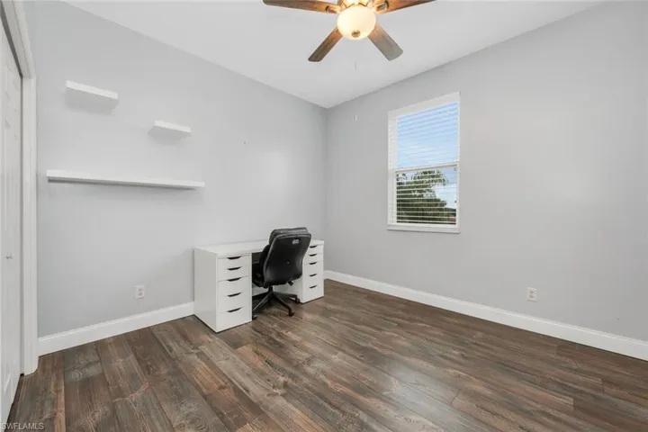 Unfurnished office featuring dark wood-style flooring and ceiling fan
