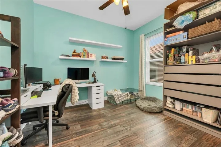 Home office featuring dark wood-style flooring and a ceiling fan