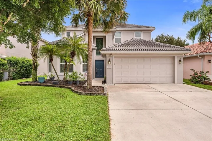 Mediterranean / spanish-style home featuring stucco siding, driveway, a front yard, and a tiled roof