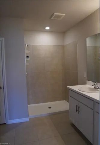 Full bathroom featuring vanity, a shower stall, light tile patterned floors, and recessed lighting