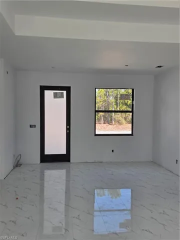 Empty room featuring light marble finish floors