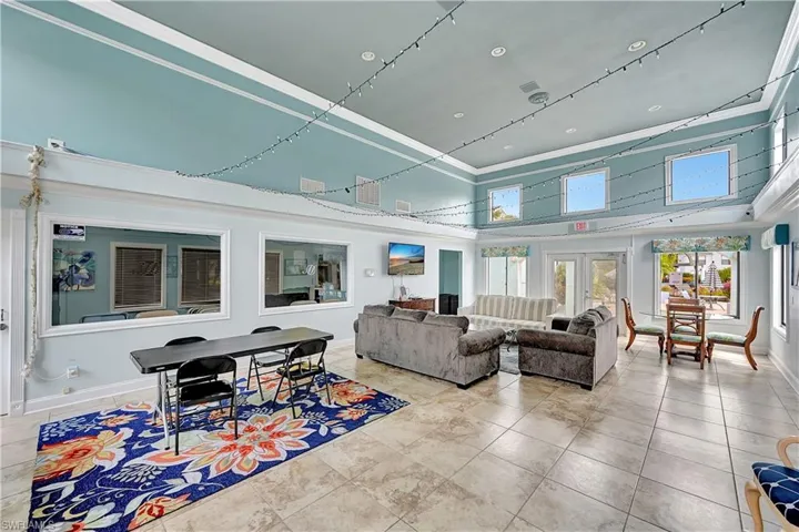 Living room featuring french doors, crown molding, and a high ceiling