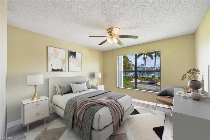 Bedroom with ceiling fan, hardwood / wood-style flooring, and a textured ceiling