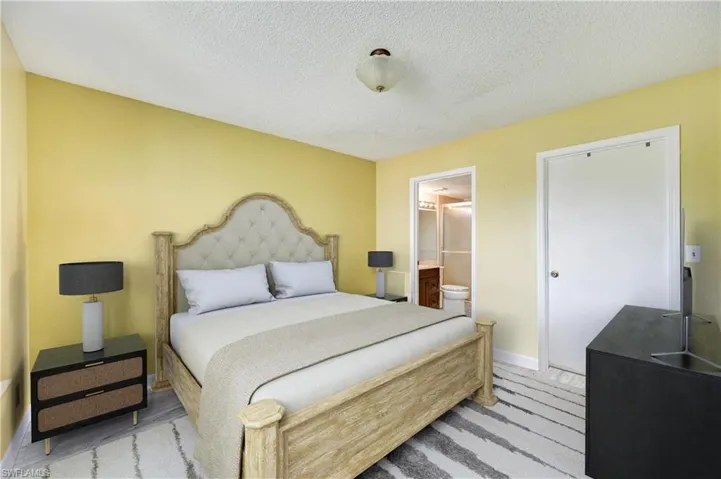 Bedroom featuring a textured ceiling and ensuite bath