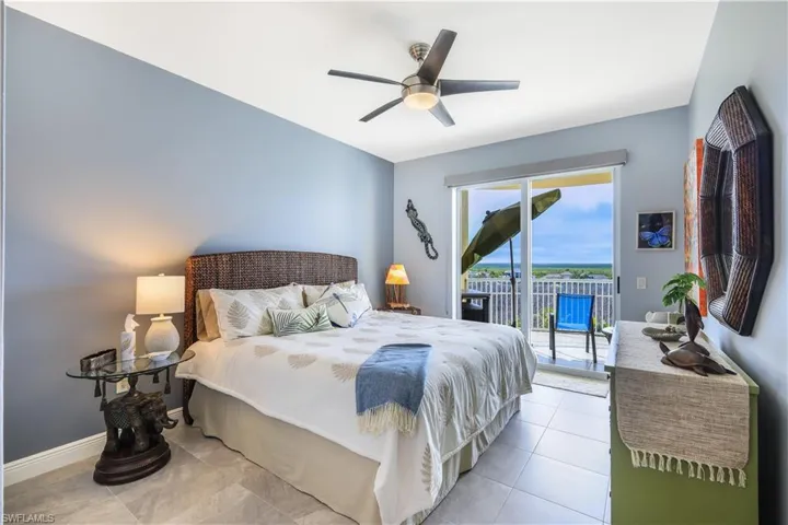 Bedroom featuring access to outside, a ceiling fan, and tile patterned floors