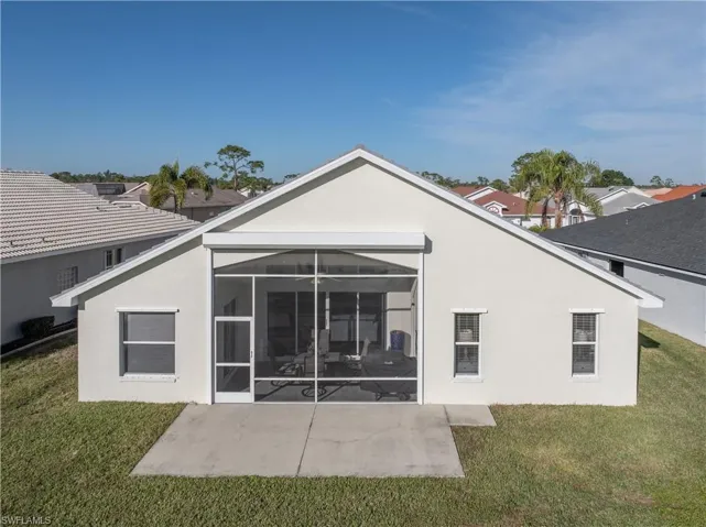 Back of house featuring a lawn and a patio area