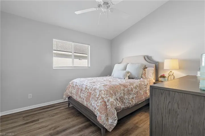 Bedroom featuring lofted ceiling, dark hardwood / wood-style floors, and ceiling fan
