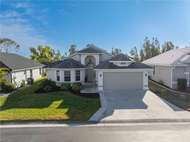 Ranch-style home with a garage, central AC unit, and a front yard
