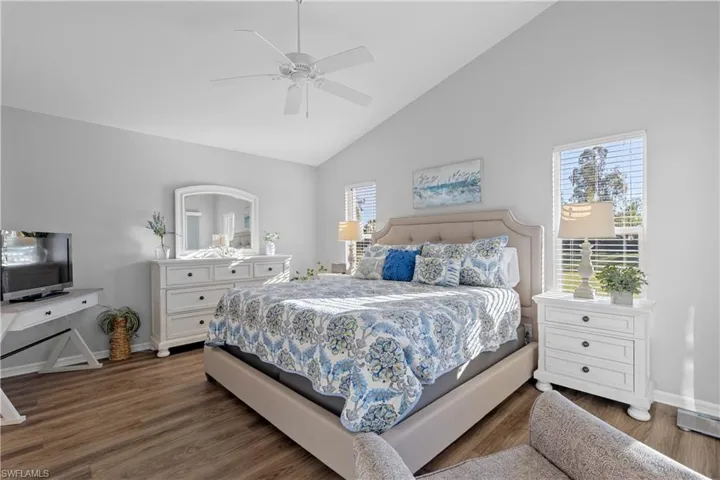Bedroom featuring ceiling fan, dark hardwood / wood-style floors, and high vaulted ceiling