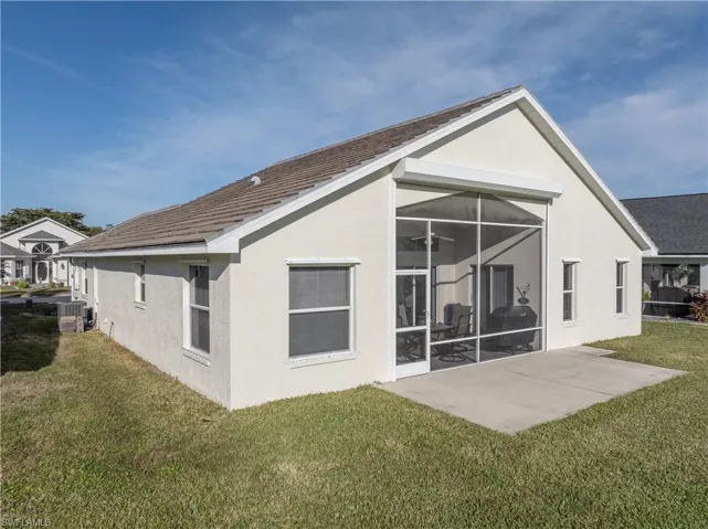 Back of house with central AC unit, a yard, a patio, and ceiling fan