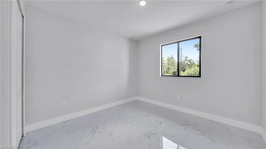 Spare room featuring marble look tiles and recessed lighting