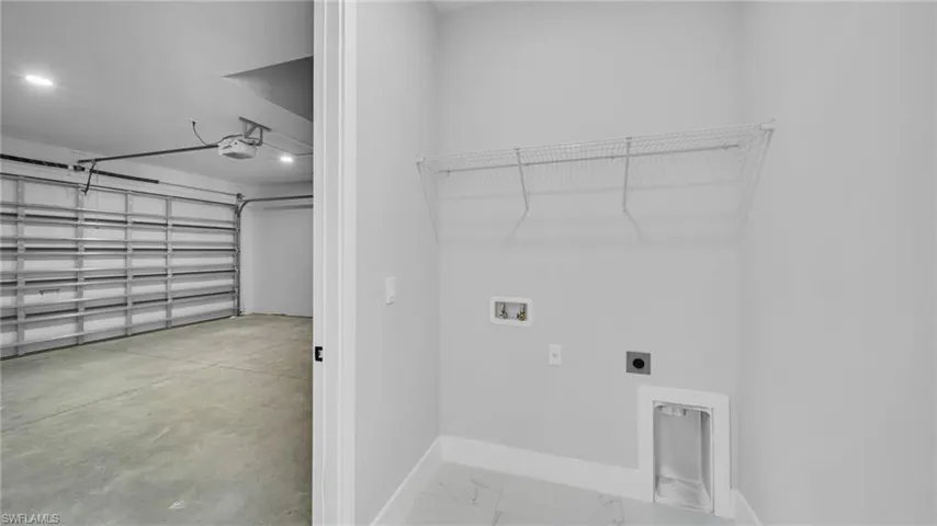 Laundry area with hookup for a washing machine, electric dryer hookup, and a garage