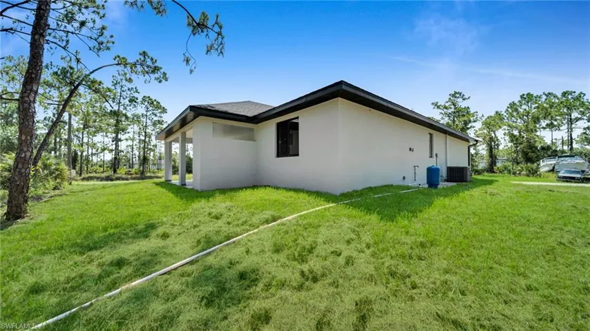 View of property exterior featuring stucco siding and a lawn