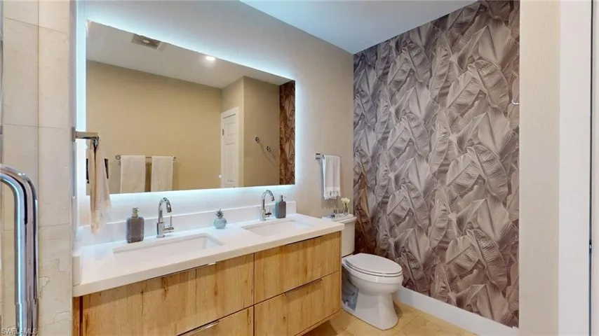 Bathroom with toilet, a shower with shower curtain, and a sink