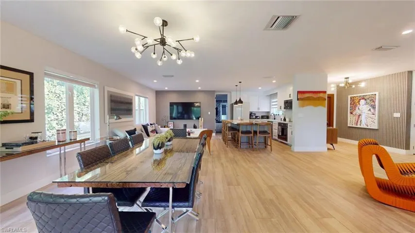 Dining area featuring an inviting chandelier, light wood-style flooring, baseboards, and visible vents