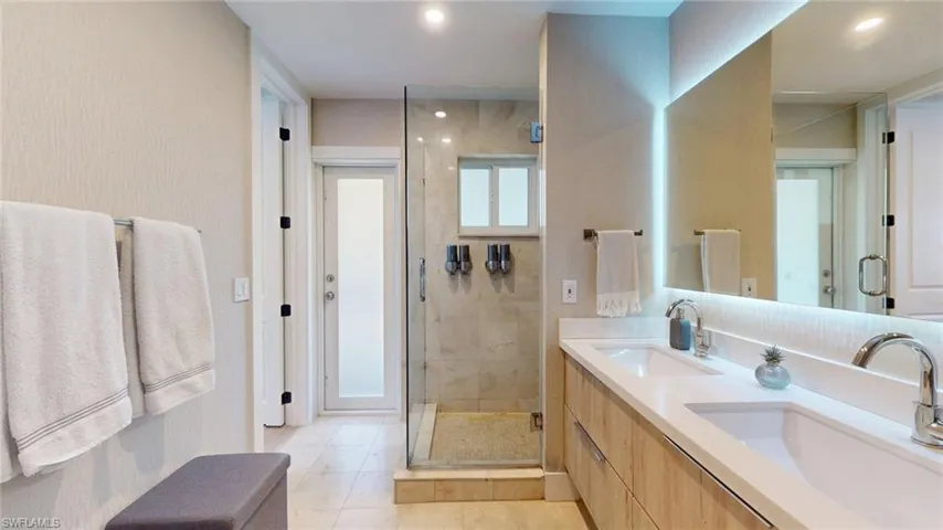 Full bathroom featuring tile patterned floors, a shower stall, and a sink