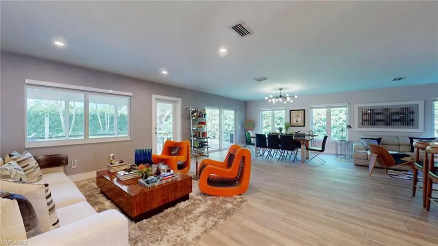 Living area featuring recessed lighting, light wood finished floors, an inviting chandelier, and visible vents