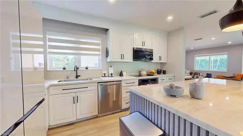 Kitchen with white cabinets, dishwasher, visible vents, and a sink