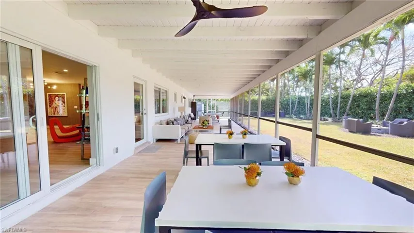 Sunroom featuring beamed ceiling, outdoor dining space, and a ceiling fan