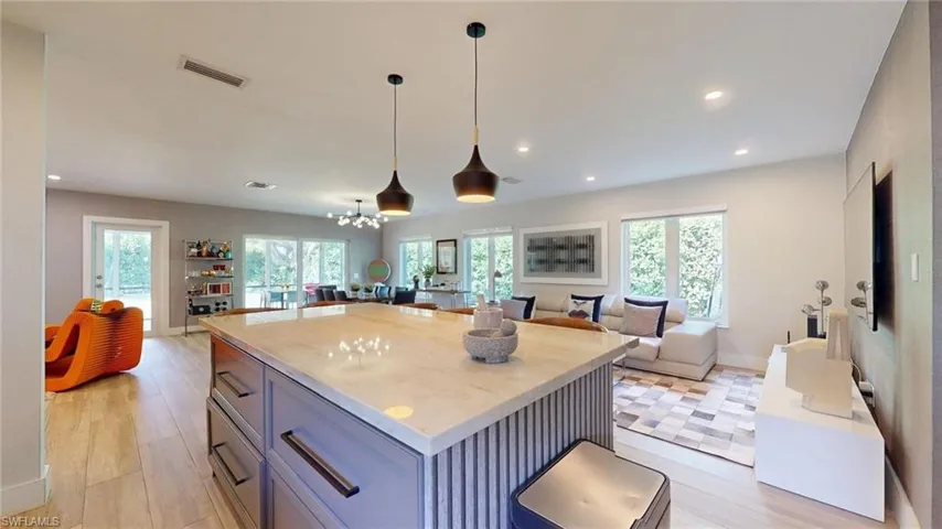 Kitchen with open floor plan, visible vents, decorative light fixtures, a kitchen island, and recessed lighting